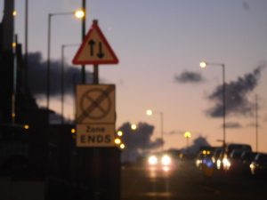 Photograph of a road with clouds and headlights